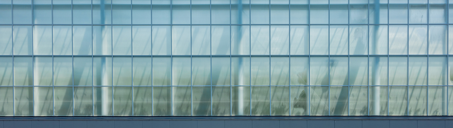 side view of a glass greenhouse with cloth with brilliant blue sky
